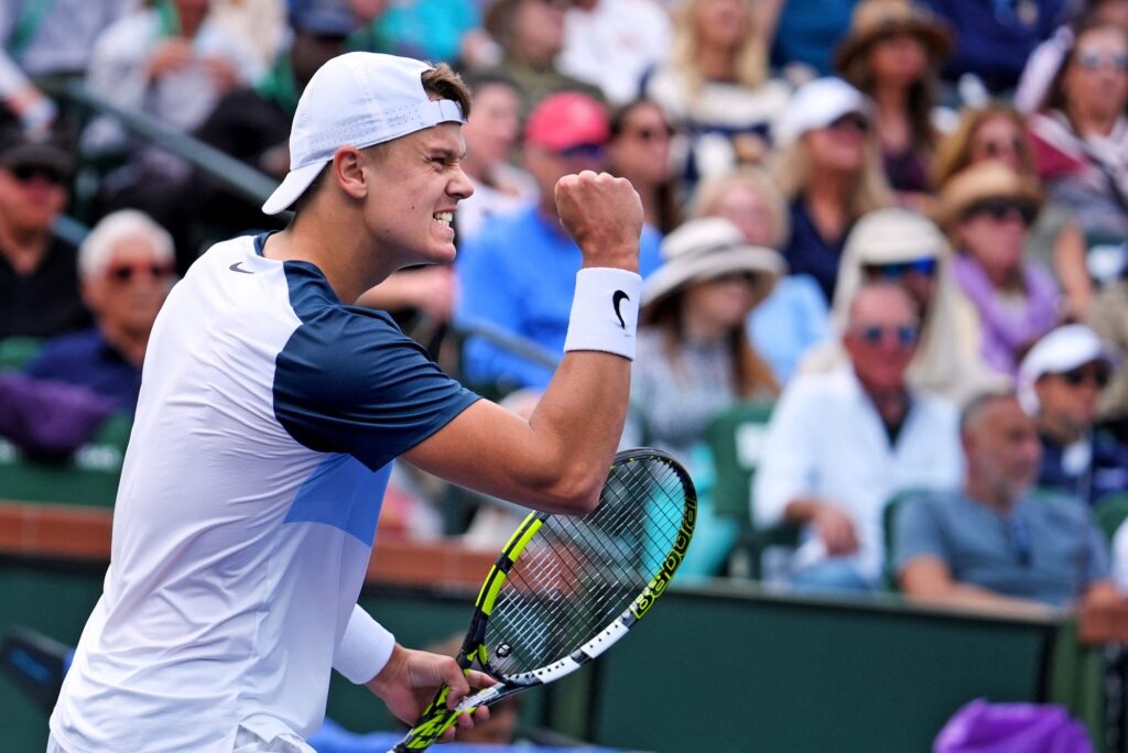 Holger Rune executing a remarkable round-the-net shot during his third-round match at the 2025 French Open.