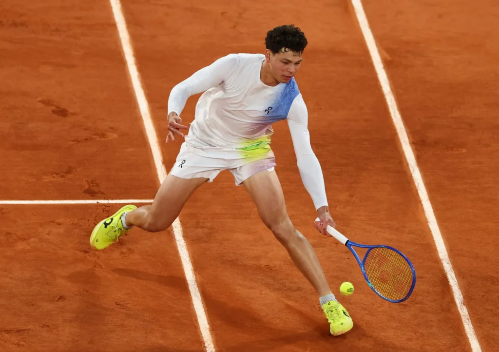 Ben Shelton triumphantly celebrates after winning his match at Roland Garros, marking his fourth-round debut.