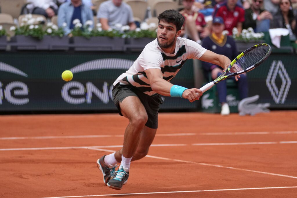 Carlos Alcaraz hits a forehand winner against Damir Dzumhur at the 2025 French Open match.