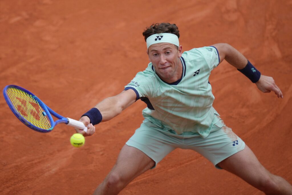 Carlos Alcaraz celebrates his comeback victory over Damir Dzumhur at the French Open, advancing to the fourth round.