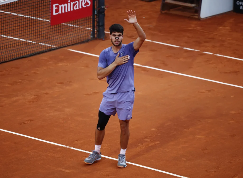 Carlos Alcaraz in action at Roland Garros, overcoming Dzumhur in a challenging four-set match.