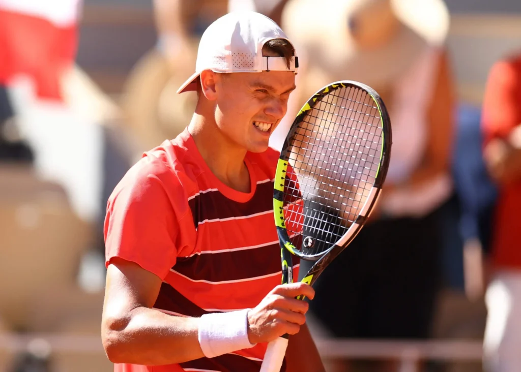 Holger Rune hits a powerful groundstroke during his match against Lorenzo Musetti at the 2025 French Open.