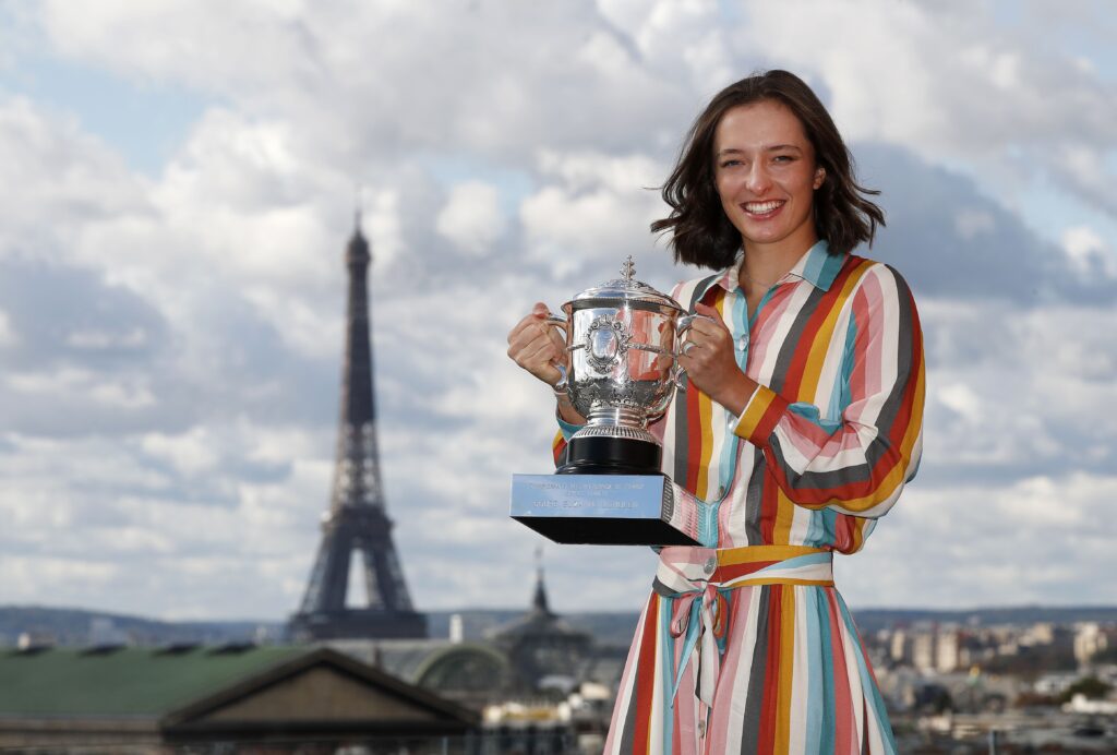 Iga Swiatek gracefully moves on clay during the 2025 French Open, showcasing her dominance in women's tennis.