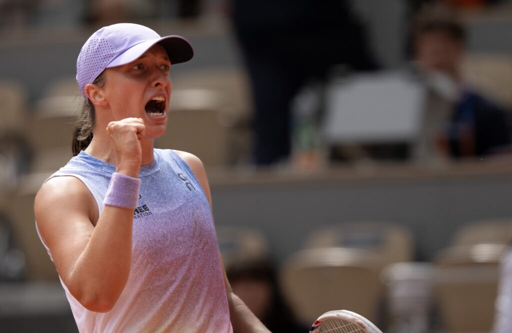 Iga Swiatek serves as she faces Elina Svitolina in the quarter-final match at the French Open.