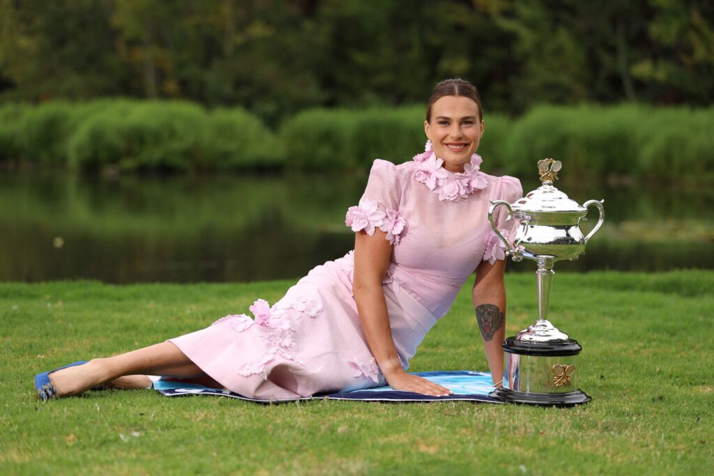 Aryna Sabalenka celebrating her Grand Slam victory over Zheng Qinwen in a tennis match, showcasing her strong performance.