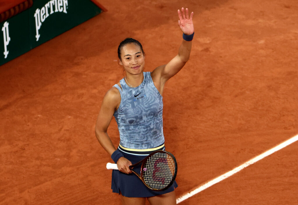 Qinwen Zheng pauses during her French Open match to challenge a call against Aryna Sabalenka, looking concerned.