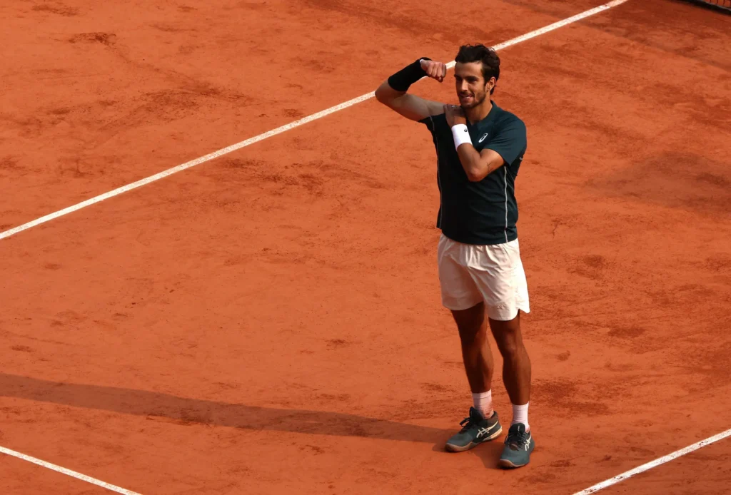 Lorenzo Musetti reacts after accidentally kicking a ball that struck a line judge during the French Open quarter-finals.
