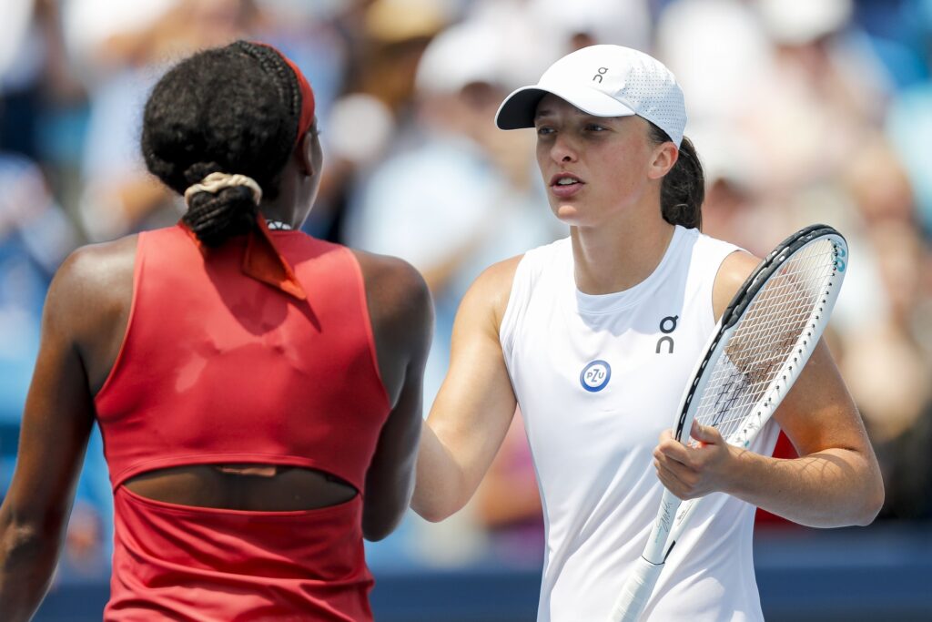 Iga Swiatek prepares for her semi-final match against Aryna Sabalenka at the French Open, showcasing her aggressive style.