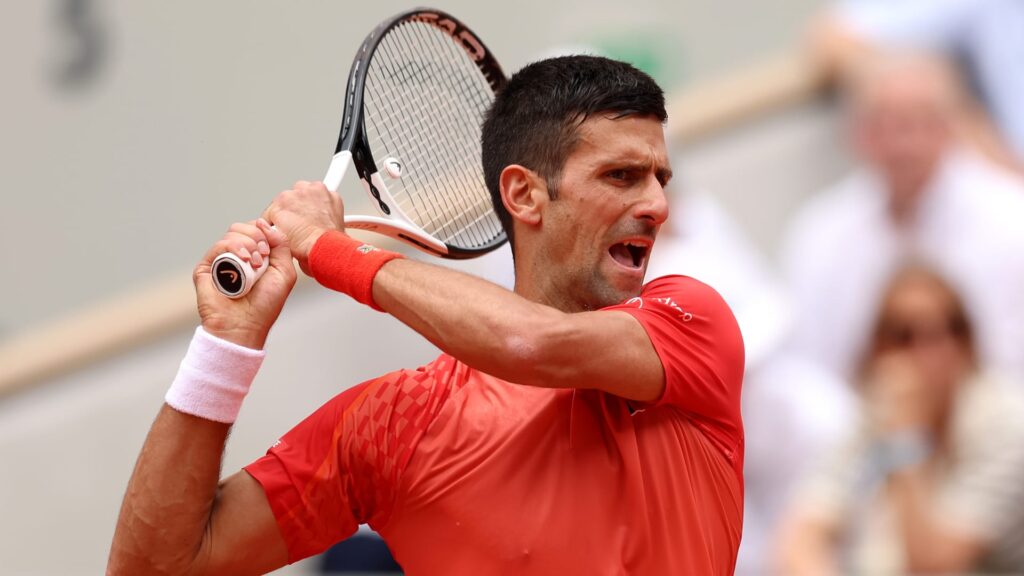Novak Djokovic executing a spectacular backhand pass during the 2025 French Open quarter-finals against Zverev.